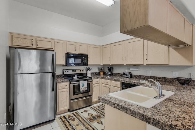 kitchen with appliances with stainless steel finishes, light brown cabinetry, and sink