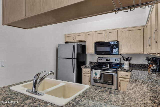 kitchen with light brown cabinets, sink, appliances with stainless steel finishes, and dark stone counters