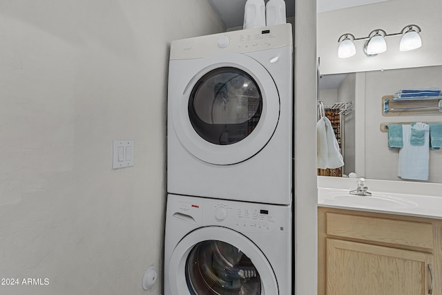 laundry area with stacked washer / drying machine and sink