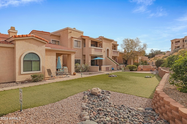 view of home's community featuring a lawn and a patio area