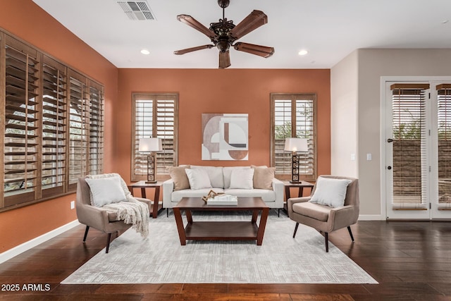 living area with wood-type flooring, visible vents, and baseboards