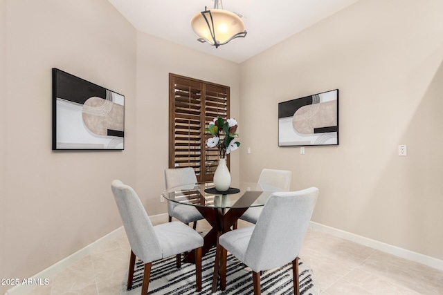 dining area featuring light tile patterned flooring and baseboards