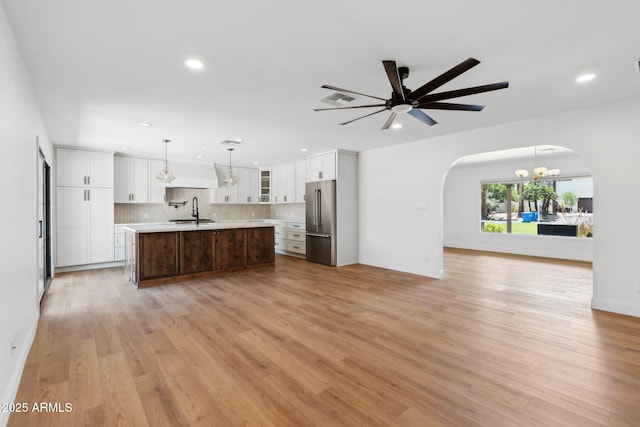 20 W Pasadena Ave, Phoenix, AZ 85013 - unfurnished living room with arched walkways, a sink, light wood finished floors, a chandelier, and recessed lighting