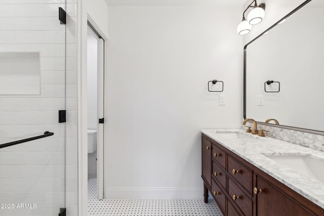 20 W Pasadena Ave, Phoenix, AZ 85013 - bathroom with double vanity, baseboards, a shower stall, and toilet