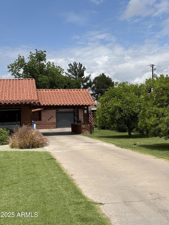 20 W Pasadena Ave, Phoenix, AZ 85013 - view of front of home featuring a tile roof, a garage, brick siding, driveway, and a front lawn