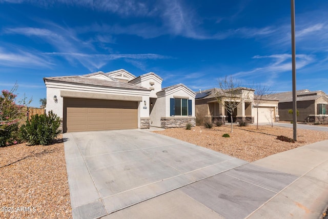 view of front of property with a garage, concrete driveway, stone siding, and stucco siding