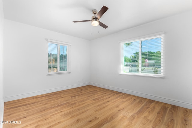 spare room with a wealth of natural light, light hardwood / wood-style flooring, and ceiling fan