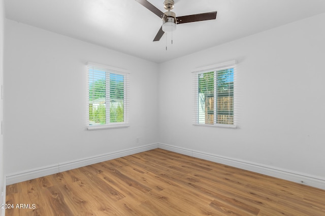 unfurnished room featuring a wealth of natural light, hardwood / wood-style floors, and ceiling fan