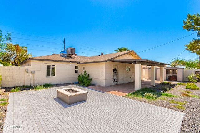 view of front of home featuring a fire pit, cooling unit, and a patio area