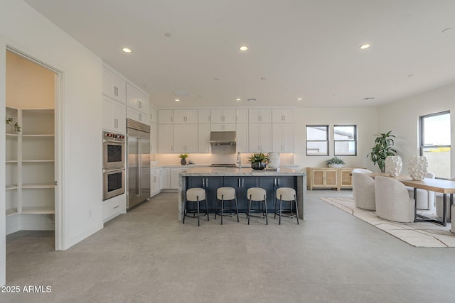 12326 E Black Rock Rd, Scottsdale, AZ 85255 - kitchen with appliances with stainless steel finishes, recessed lighting, white cabinetry, and under cabinet range hood