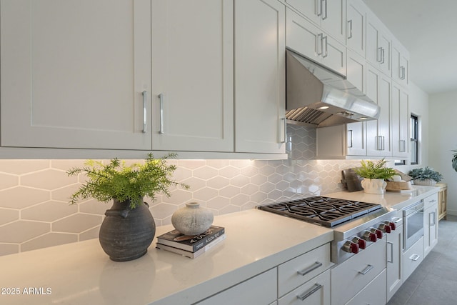 12326 E Black Rock Rd, Scottsdale, AZ 85255 - kitchen featuring light countertops, white cabinets, under cabinet range hood, decorative backsplash, and stainless steel gas stovetop