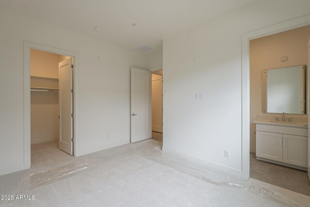 12326 E Black Rock Rd, Scottsdale, AZ 85255 - unfurnished bedroom with ensuite bathroom, baseboards, a sink, a spacious closet, and light colored carpet