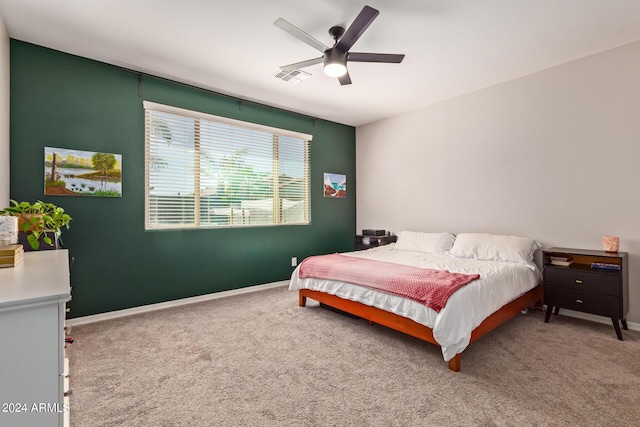 carpeted bedroom with a ceiling fan, visible vents, and baseboards