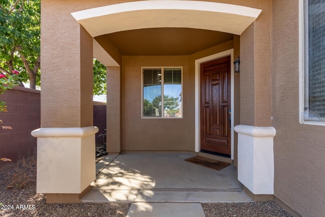 property entrance with fence and stucco siding