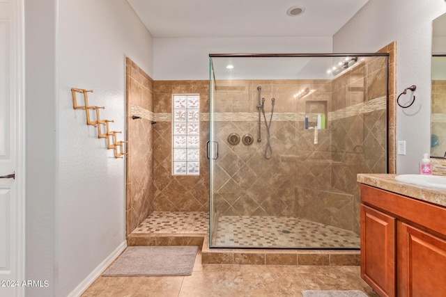 bathroom with a shower stall, tile patterned flooring, and vanity