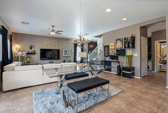 tiled living room featuring ceiling fan with notable chandelier