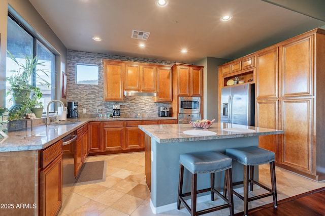 16336 E Ridgeline Dr, Fountain Hills, AZ 85268 - kitchen featuring light stone counters, under cabinet range hood, stainless steel appliances, visible vents, and a sink