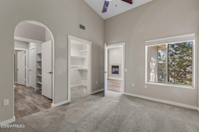 4343 E Soliere Ave Unit 2070, Flagstaff, AZ 86004 - unfurnished bedroom with high vaulted ceiling, carpet floors, a walk in closet, baseboards, and visible vents