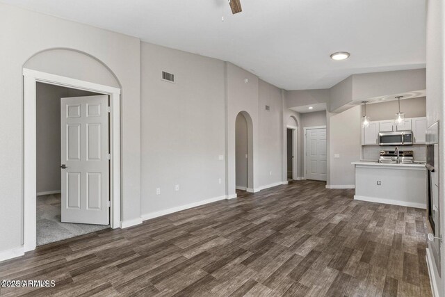 4343 E Soliere Ave Unit 2070, Flagstaff, AZ 86004 - unfurnished living room with dark wood-style floors, baseboards, ceiling fan, and visible vents