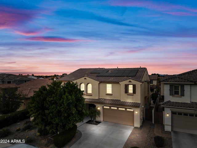 view of front of home featuring solar panels and a garage