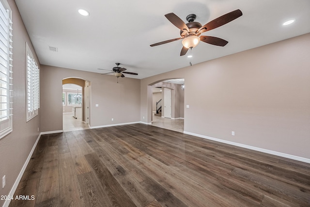 unfurnished living room with ceiling fan and dark hardwood / wood-style flooring