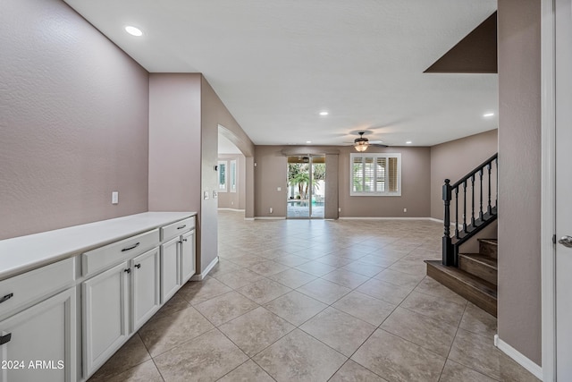 interior space featuring white cabinetry, ceiling fan, and light tile patterned flooring