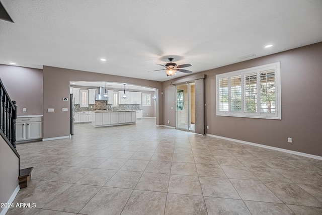 unfurnished living room featuring ceiling fan and light tile patterned flooring