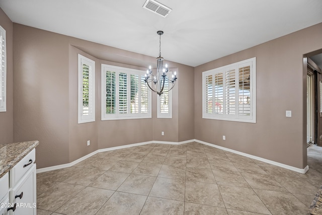 unfurnished dining area featuring light tile patterned floors, an inviting chandelier, and a wealth of natural light