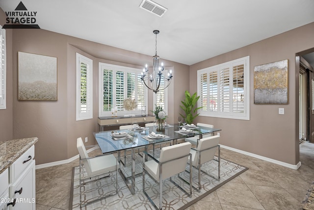 dining space with a chandelier and light tile patterned flooring