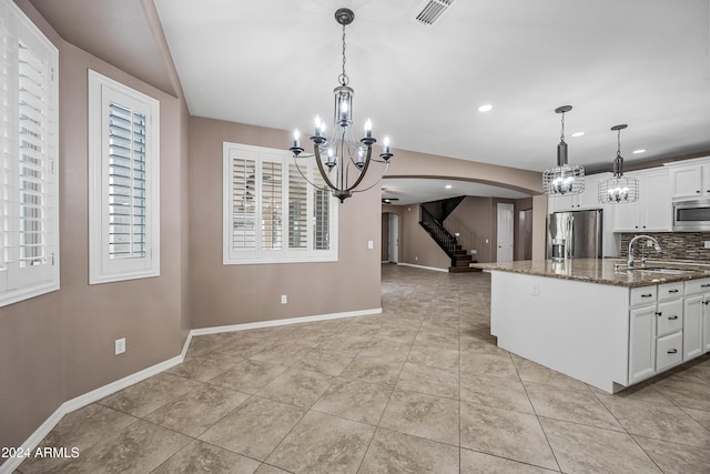 kitchen featuring white cabinetry, sink, stainless steel appliances, tasteful backsplash, and dark stone counters