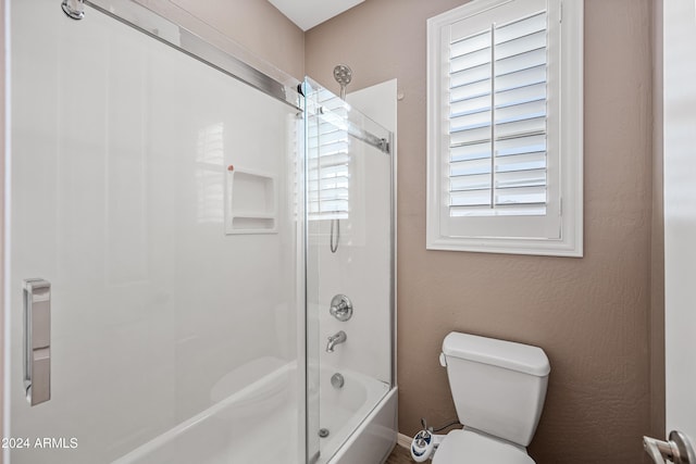 bathroom with combined bath / shower with glass door, toilet, and plenty of natural light