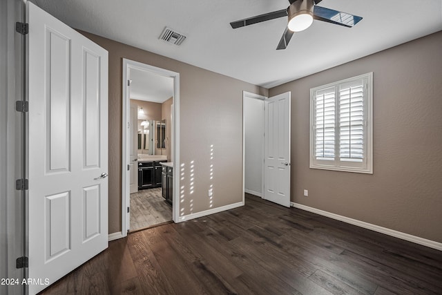 unfurnished bedroom with ceiling fan, dark hardwood / wood-style flooring, and connected bathroom