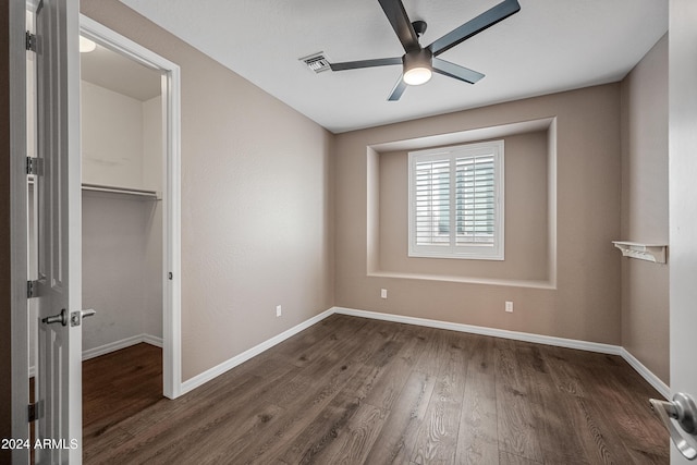 unfurnished bedroom featuring ceiling fan, dark hardwood / wood-style floors, and a closet