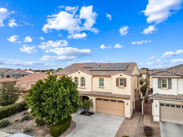 mediterranean / spanish-style home with solar panels and a garage