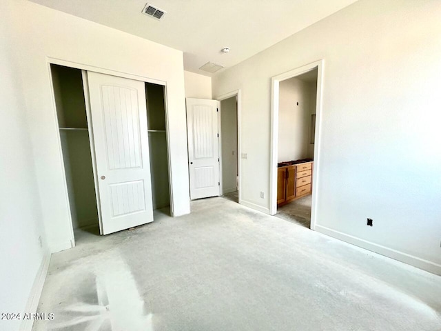 carpeted bedroom featuring ensuite bath and a closet