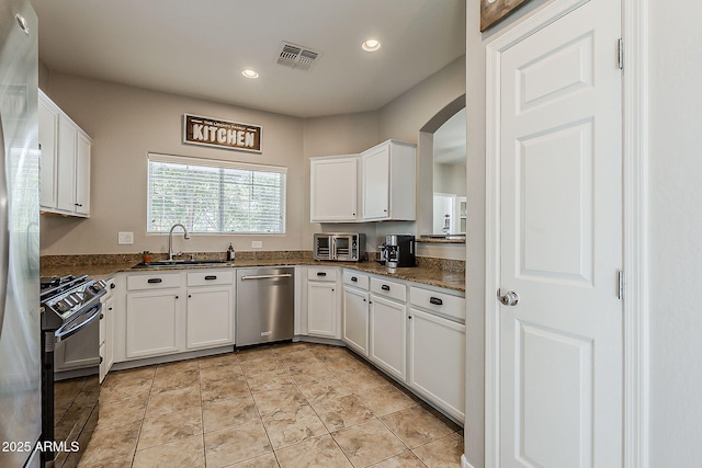 1482 S Banning St, Gilbert, AZ 85296 - kitchen with stainless steel appliances, a sink, arched walkways, white cabinets, and recessed lighting