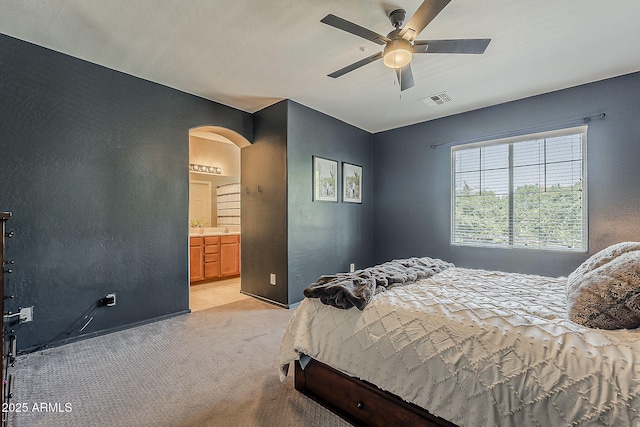 1482 S Banning St, Gilbert, AZ 85296 - bedroom featuring arched walkways, light colored carpet, a textured wall, a ceiling fan, and ensuite bath