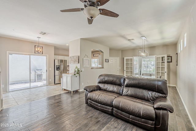 1482 S Banning St, Gilbert, AZ 85296 - living room with light wood-style floors, baseboards, ceiling fan, and arched walkways