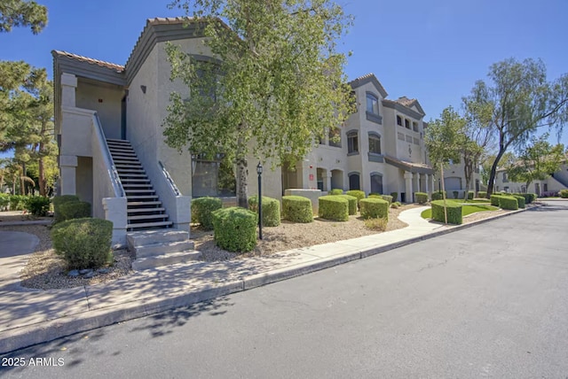 view of building exterior featuring a residential view and stairs