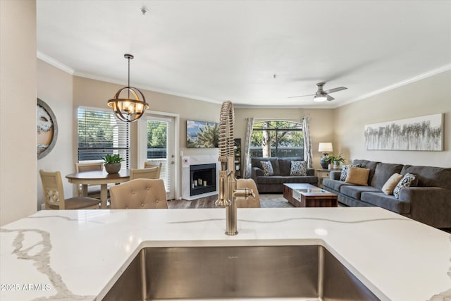 interior space featuring crown molding, open floor plan, light countertops, and a fireplace