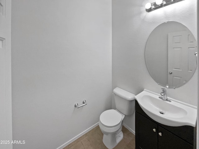 bathroom with baseboards, vanity, toilet, and tile patterned floors