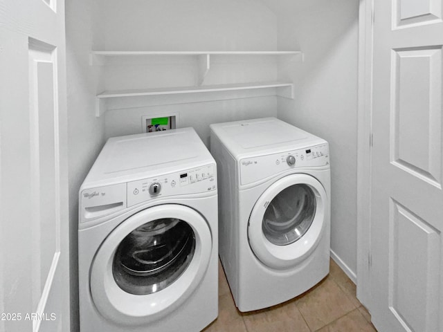 washroom featuring laundry area, washing machine and dryer, and light tile patterned floors