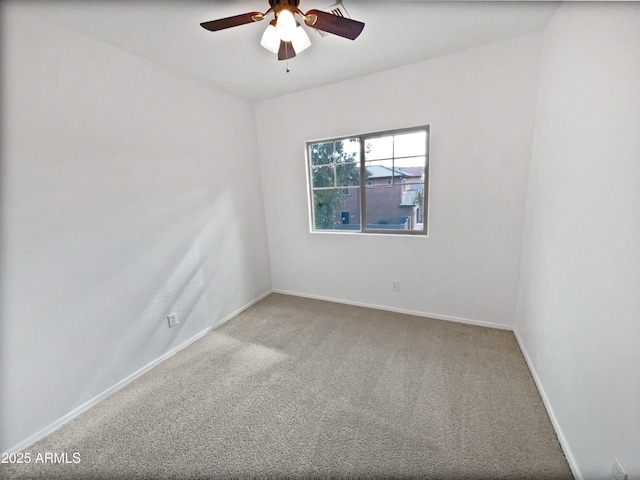 spare room with carpet, baseboards, and a ceiling fan