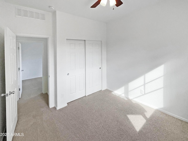 unfurnished bedroom featuring ceiling fan, a closet, carpet, and visible vents