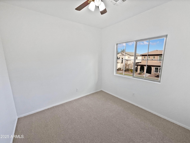 unfurnished room featuring carpet floors, visible vents, baseboards, and a ceiling fan