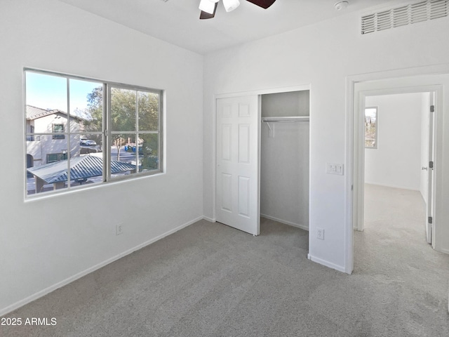 unfurnished bedroom with carpet floors, a ceiling fan, baseboards, and a closet