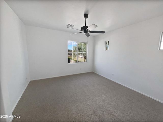 unfurnished room with carpet, baseboards, visible vents, and ceiling fan