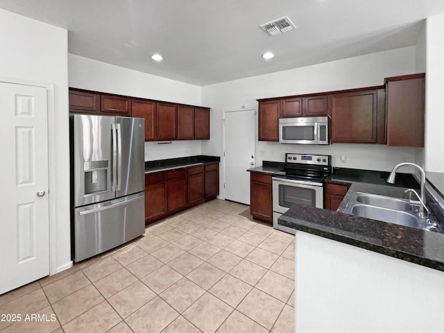 kitchen featuring stainless steel appliances, light tile patterned flooring, a sink, and visible vents