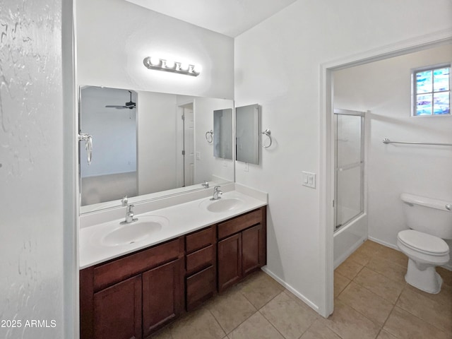 full bathroom with toilet, tile patterned flooring, double vanity, and a sink