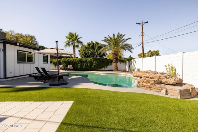 view of swimming pool with a patio and a yard